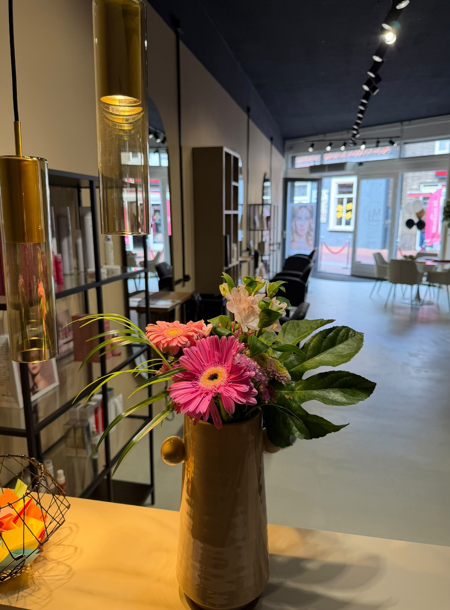 Gouden vaas met bloemen op tafel, met zicht naar de straat